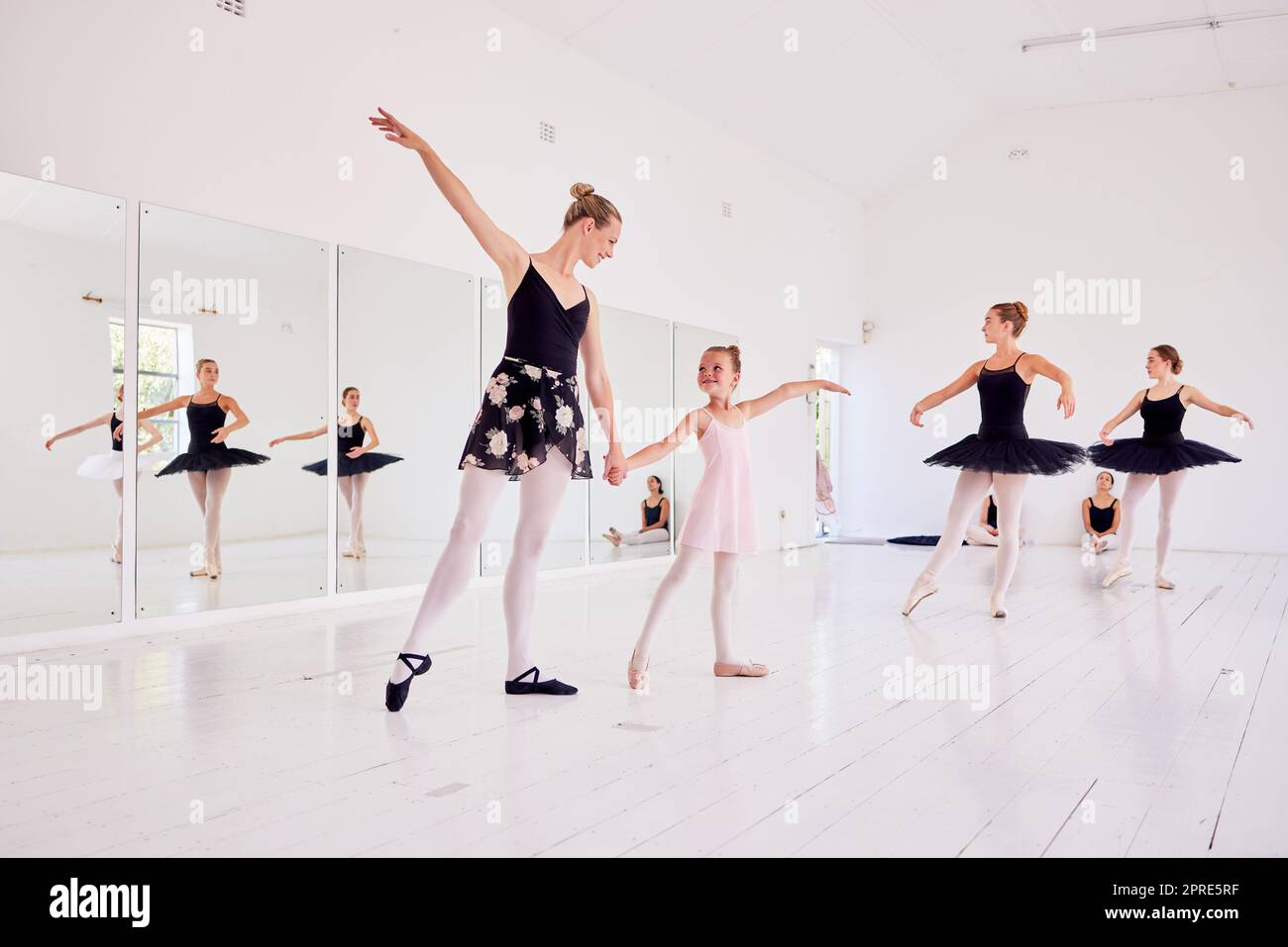 Ballet instructor or teacher teaching a young dancer in a class or dance studio preparing her