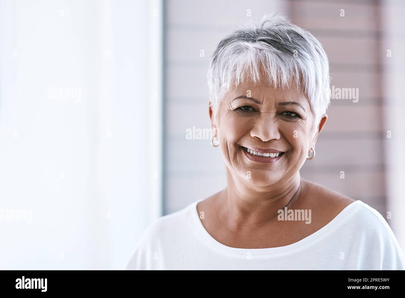 Portrait of smiling mature woman in empty room stock photo