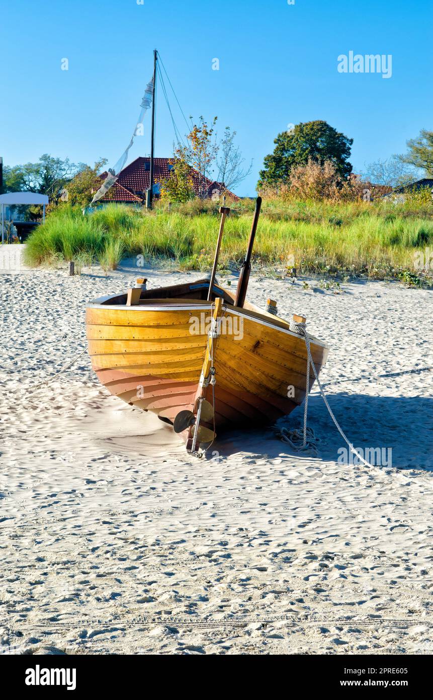 Small wooden fishing boat lies on the sandy beach by the sea Stock ...