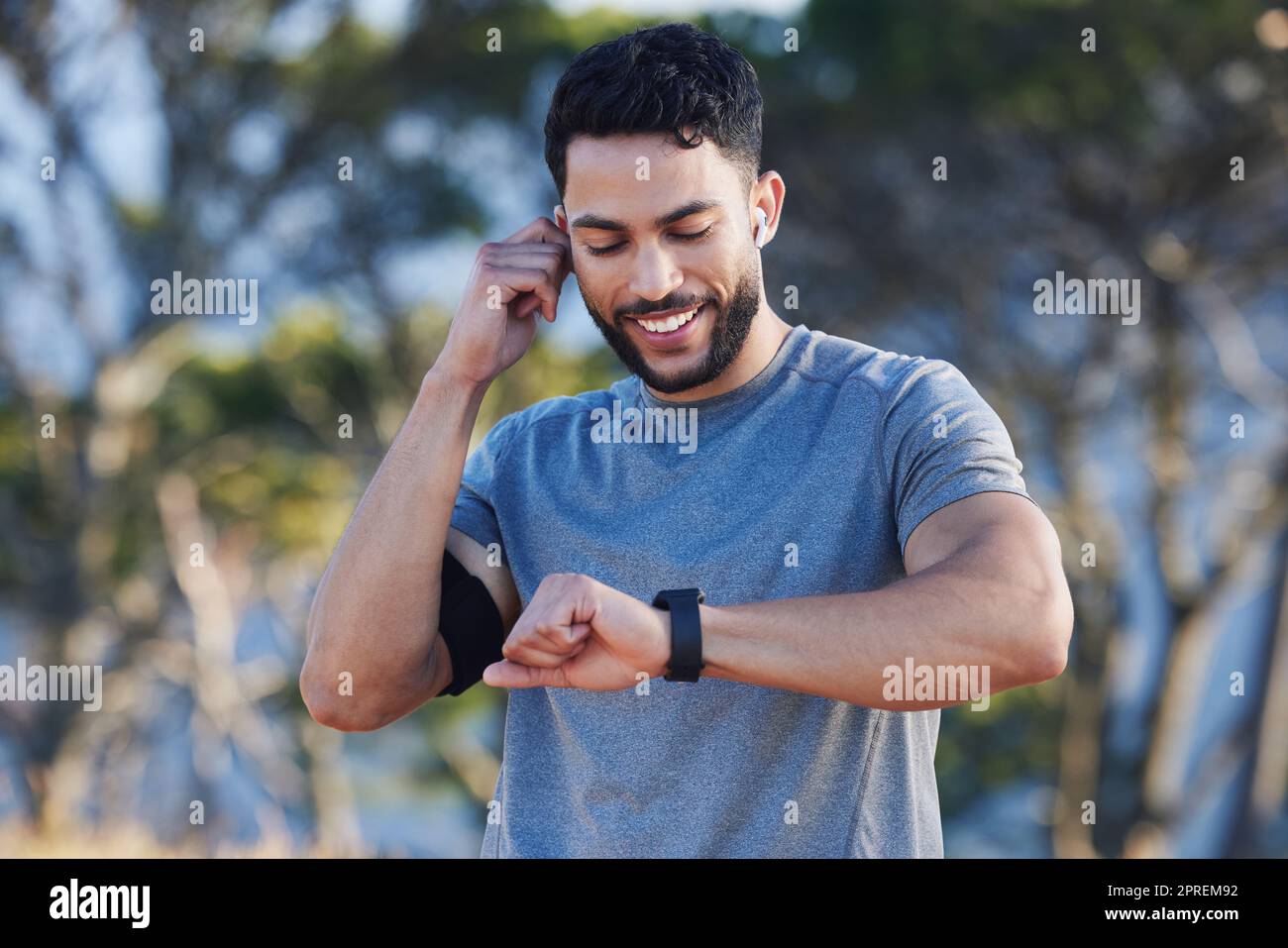 Man, runner and smartwatch outdoor for workout listening to music, radio or streaming on web