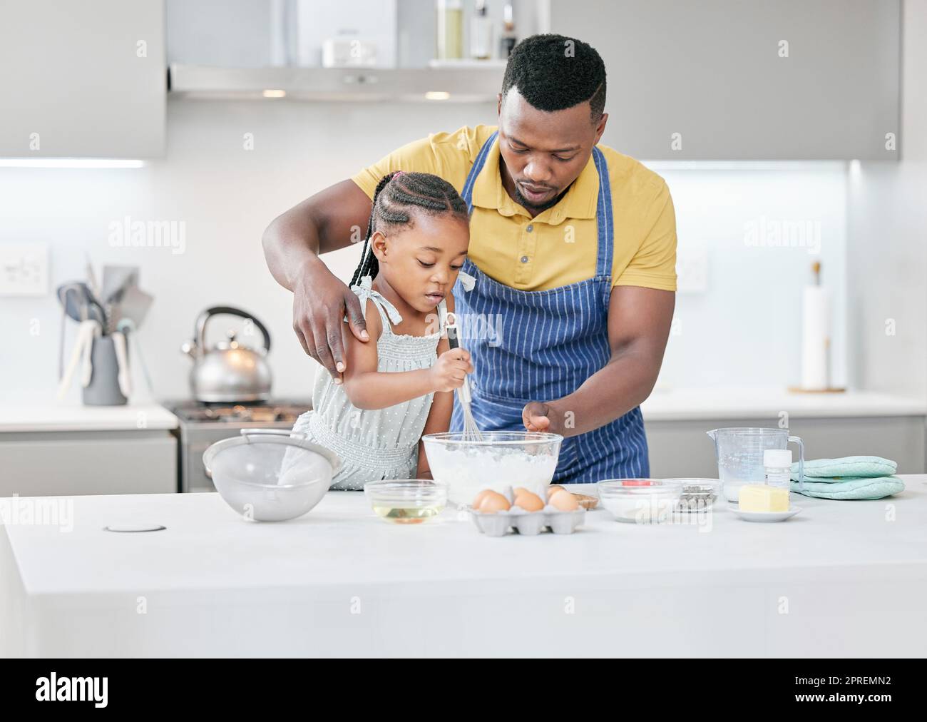 Dont whisk it so fast. a handsome young father bonding with his daughter and helping her bake in