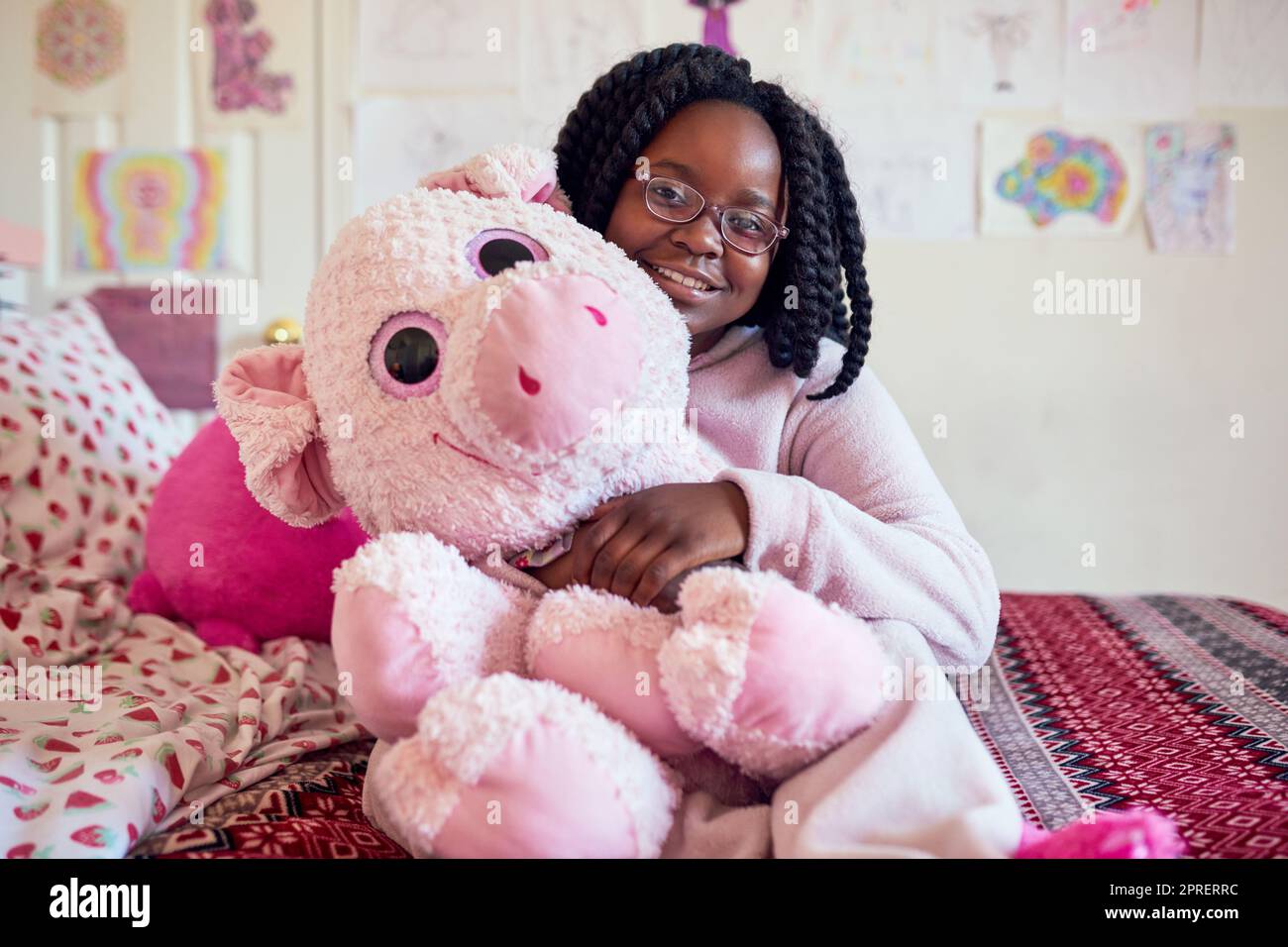 More than just a toy, hes my best friend. Portrait of an adorable little girl holding a plush toy while sitting on her bed in her bedroom. Stock Photo