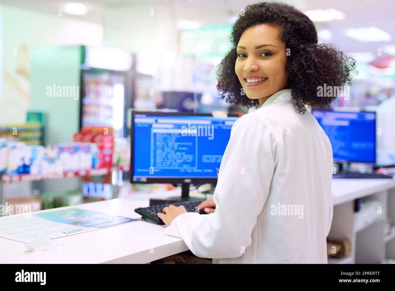 Would you like a receipt. a pharmacist working on a computer in a pharmacy. Stock Photo
