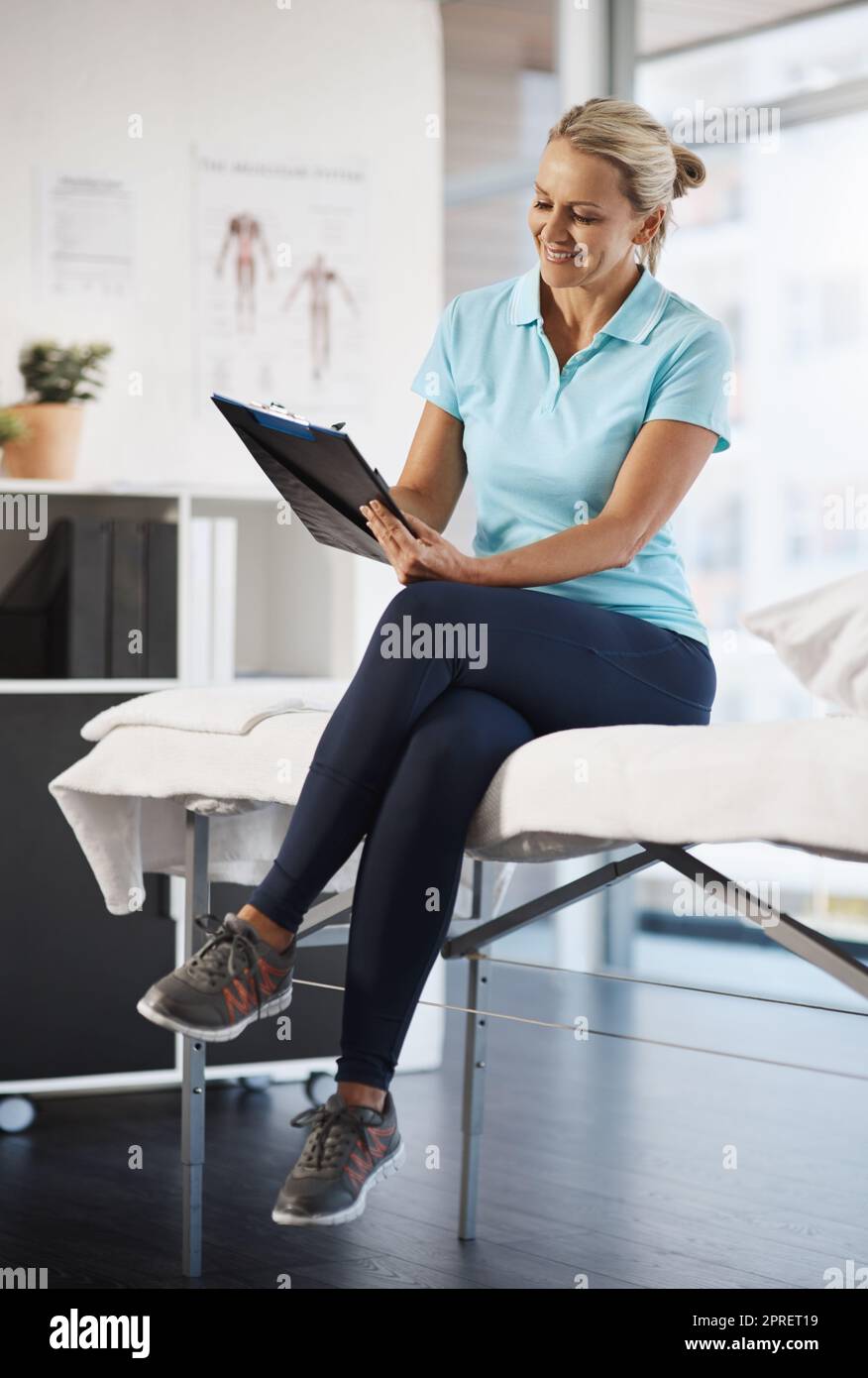 Updating her records. Full length shot of a mature female physiotherapist working in her office. Stock Photo