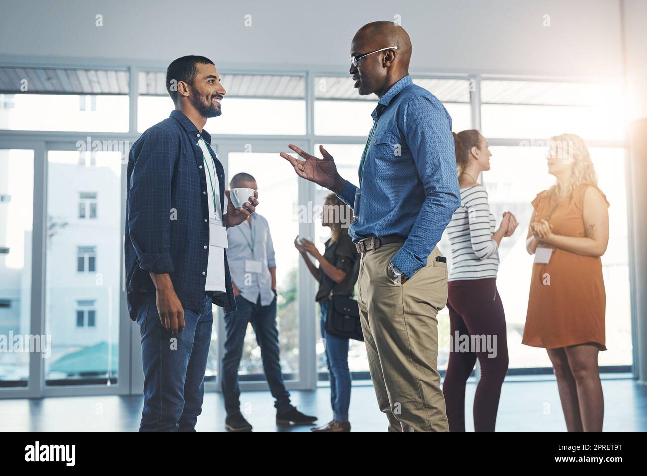 Creative men talking at networking event, sharing startup ideas and