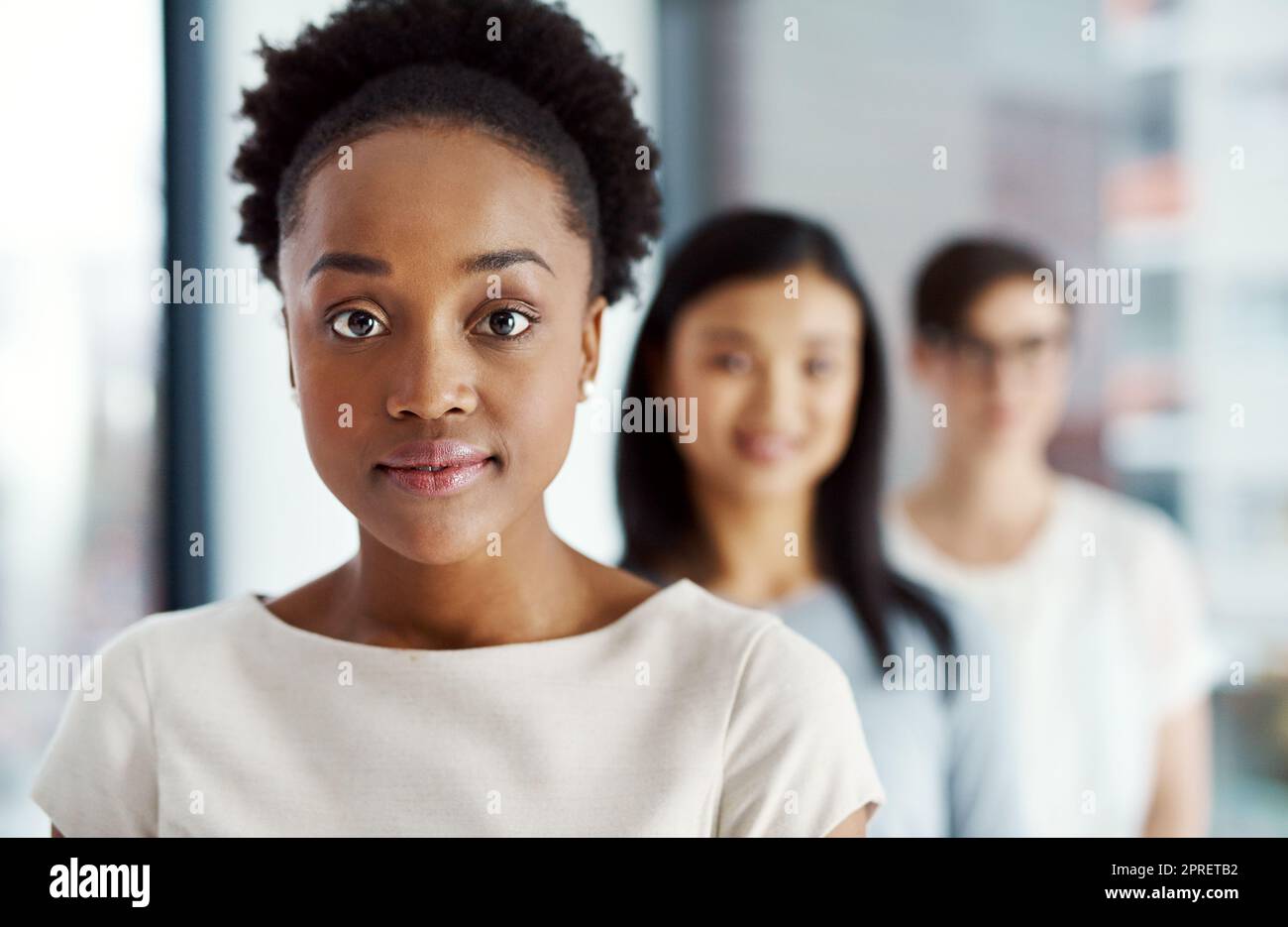 Woman leading diverse team of creative people with motivation, power and a vision for a global business. Closeup portrait, headshot and face of serious black leader standing in line with colleagues Stock Photo