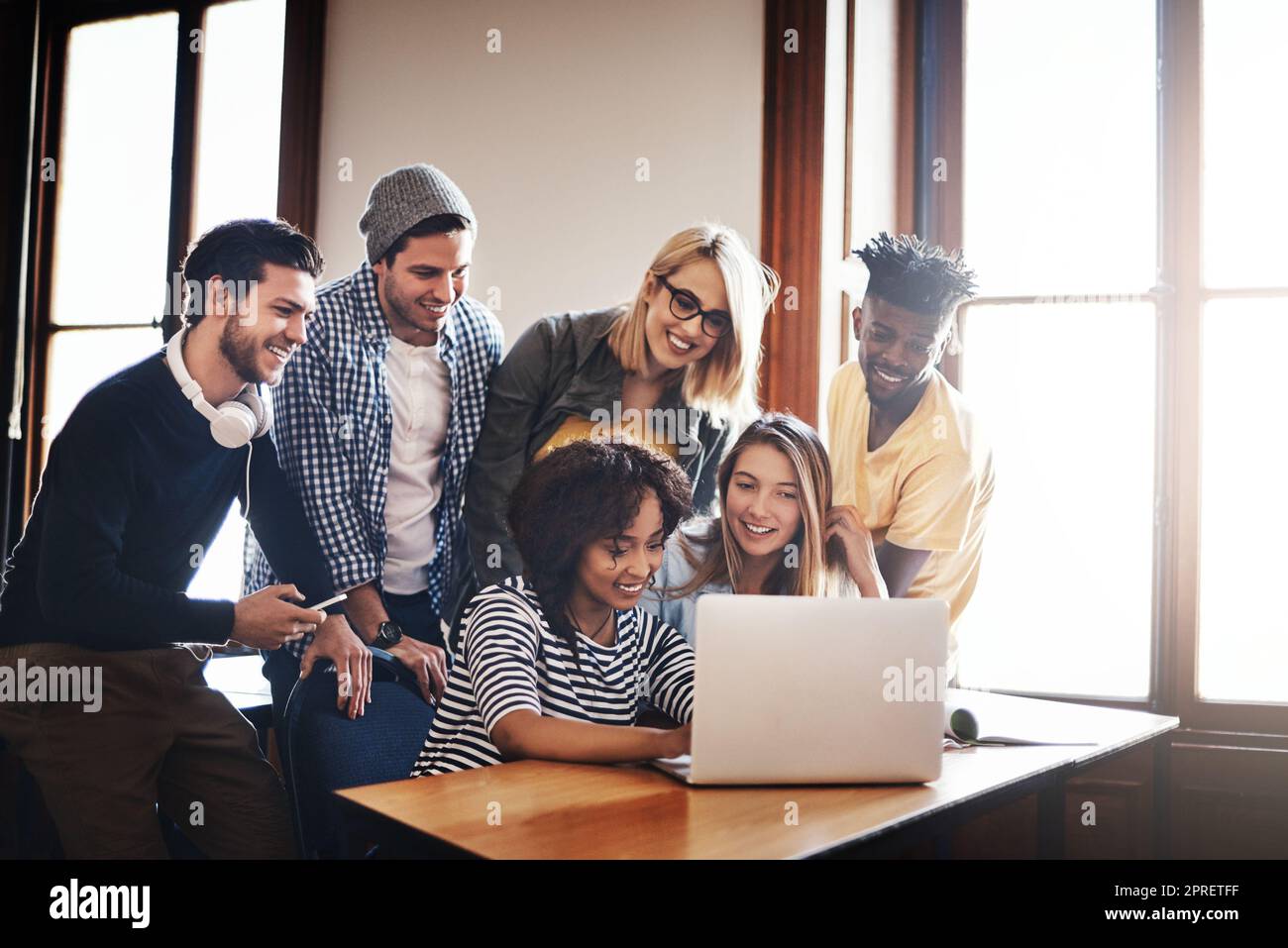 Going over the new assignment together. a group of university students working on an assignment together in class. Stock Photo