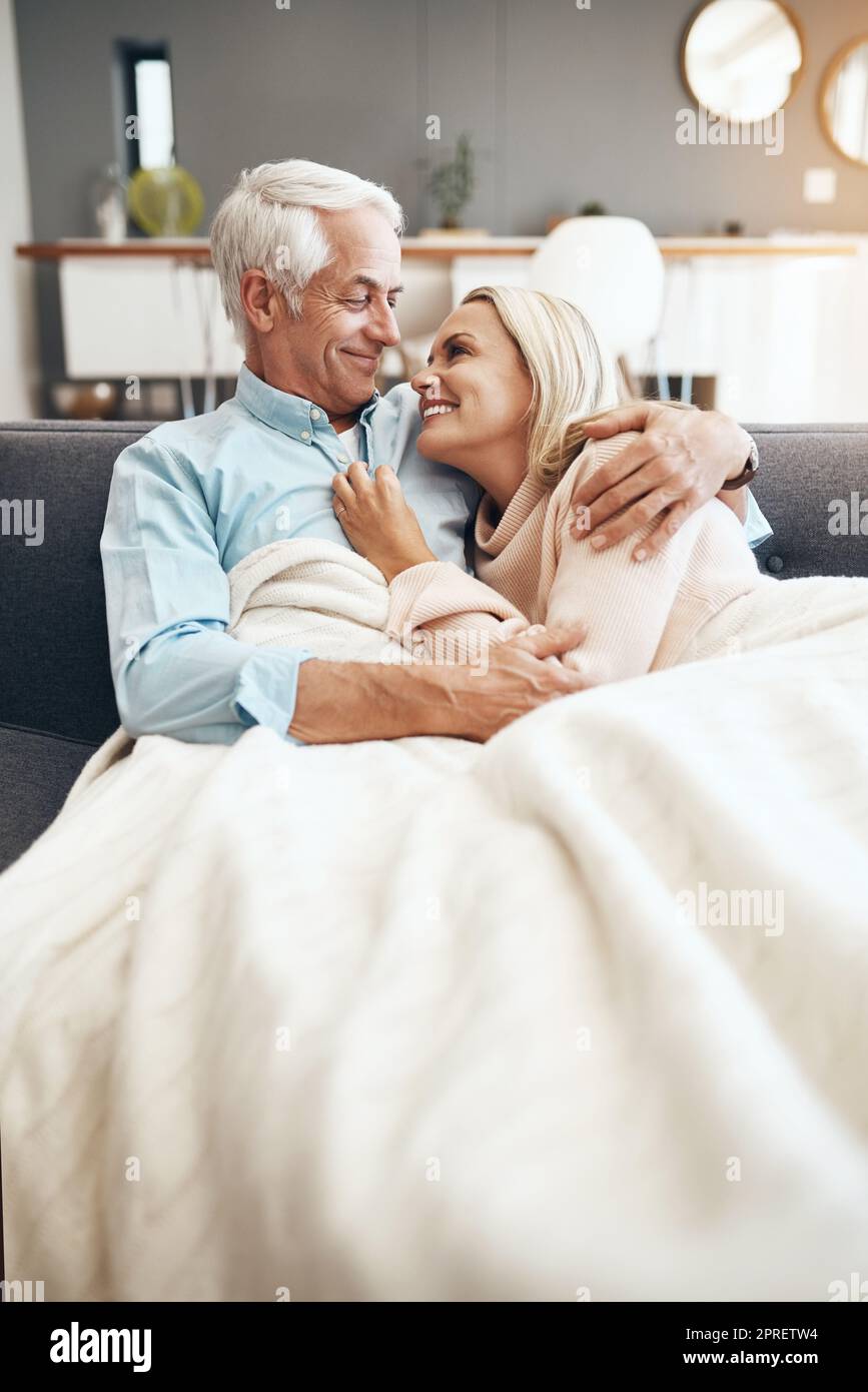 Enjoying this comfy and cosy weekend. an affectionate mature couple relaxing on the sofa at home. Stock Photo