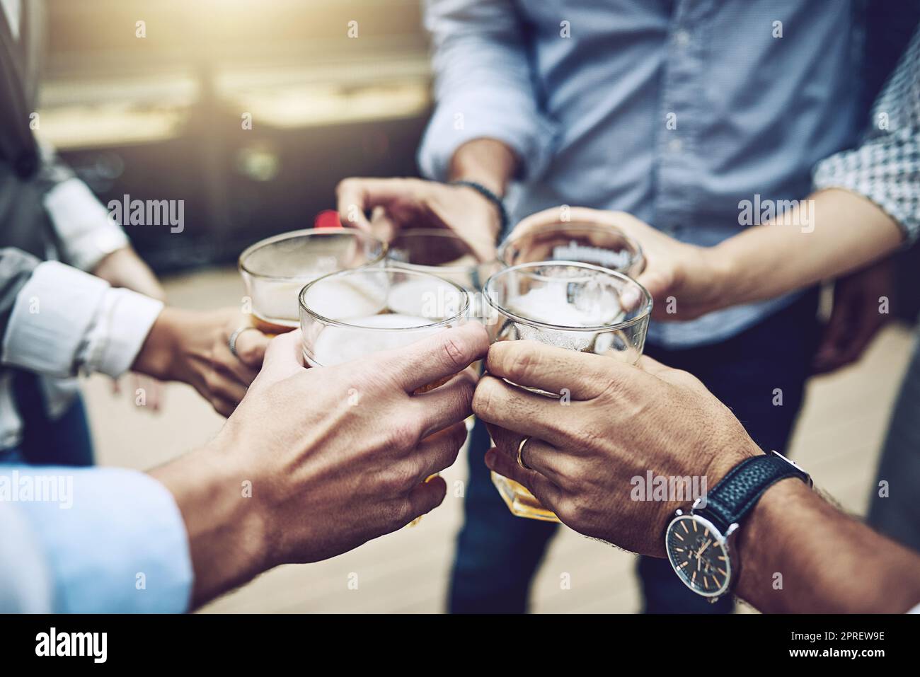 Heres to the first one. a group of unrecognizable work colleagues having a celebratory toast together with beer outside during the day. Stock Photo