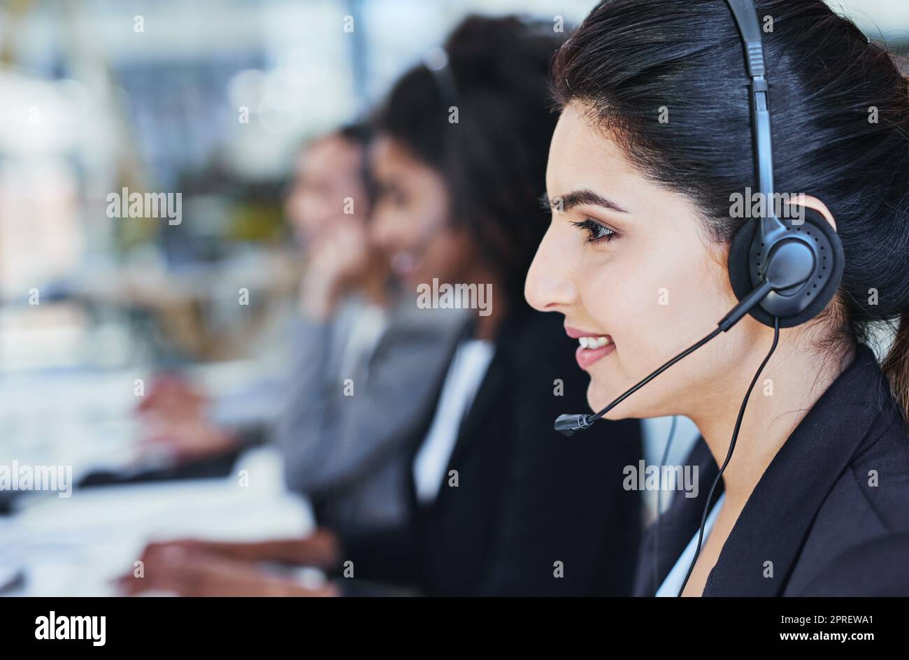 Youve reached our customer care, how may I assist. a young woman working in a call centre. Stock Photo