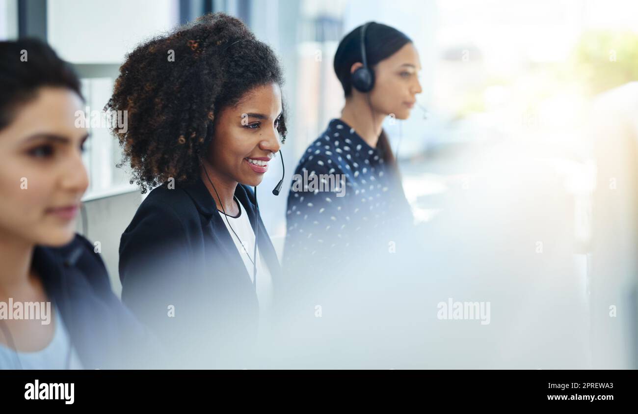 We serve with the utmost professionalism. young women working in a call centre. Stock Photo
