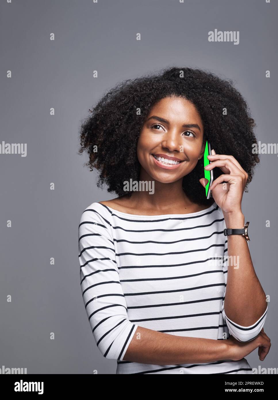 Sometimes a text message just wont cut it. Studio shot of a young woman using a mobile phone against a gray background. Stock Photo
