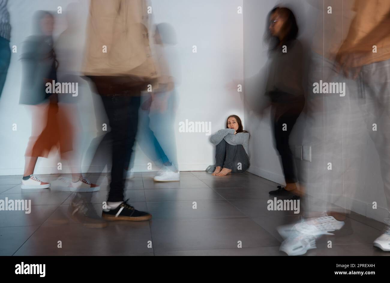 No one can hear you scream. a young woman sitting on the floor with people around her Stock Photo