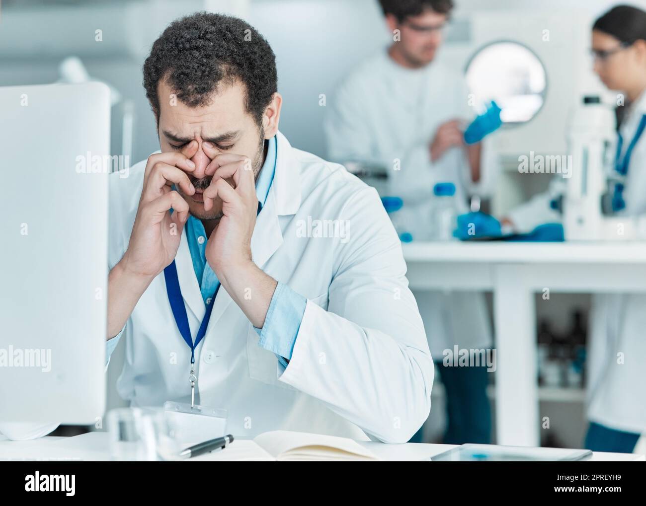 Oh no, I made an irreversible mistake. a young scientist looking stressed out while working on a computer in a lab Stock Photo