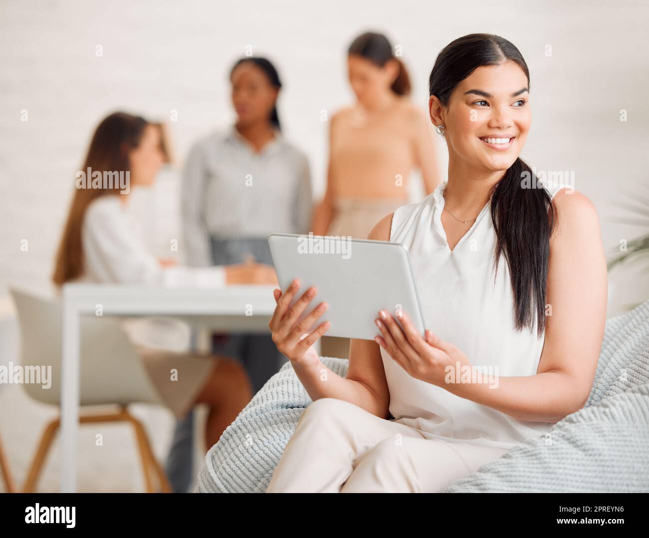 Trendy, fashionable and elegant fashion designer working on clothing designs on a digital tablet. Group of young, creative and professional stylists using teamwork and collaboration for new ideas Stock Photo
