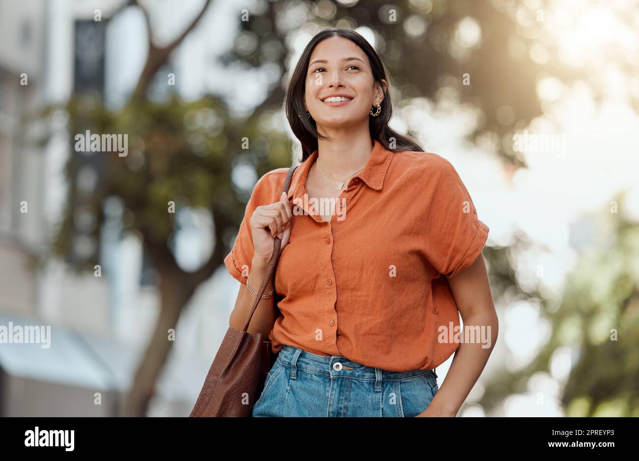 Stylish, happy and trendy student walking in a city, commuting to a college and enjoying a weekend break downtown. Smiling, edgy or funky woman exploring, visiting and enjoying town while sightseeing Stock Photo