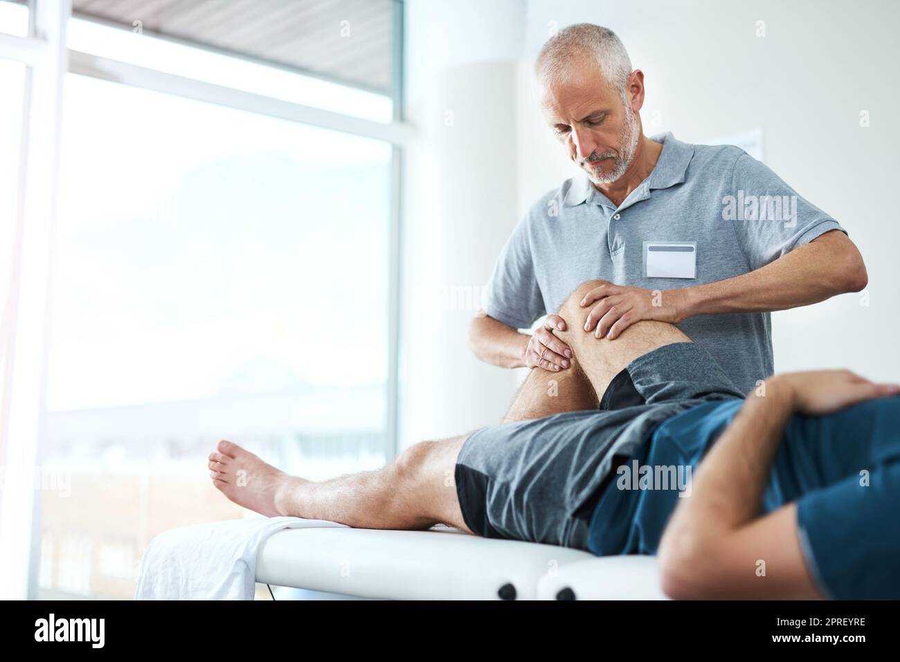 Were going to take recovery one step at a time. a handsome mature male physiotherapist treating an unrecognizable patient. Stock Photo