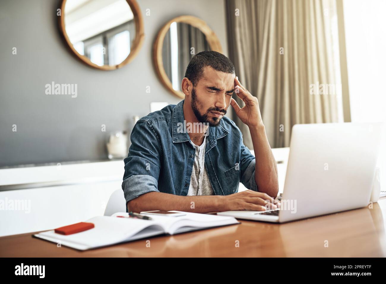 Man working at home using laptop near the big window. Remote work, online  job, work from home. Stock Photo