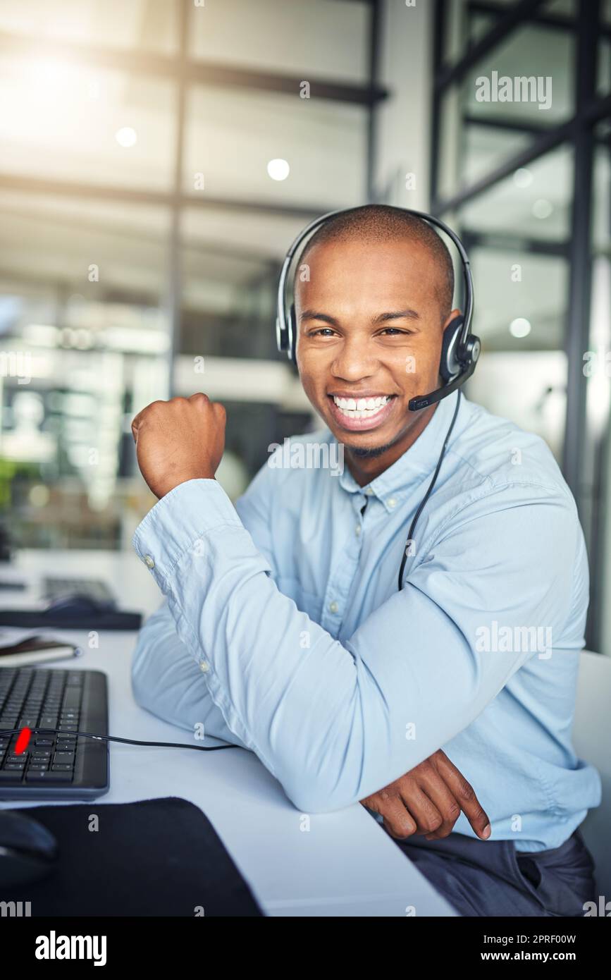 Helping customers is what he does. a young handsome male customer support agent working in the office. Stock Photo