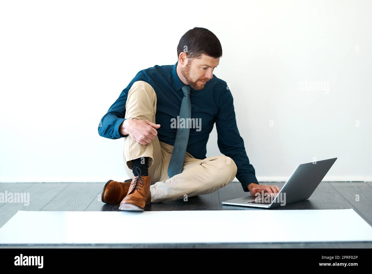 Working on his latest building plan. Full length shot of a handsome mature male architect working on his laptop. Stock Photo