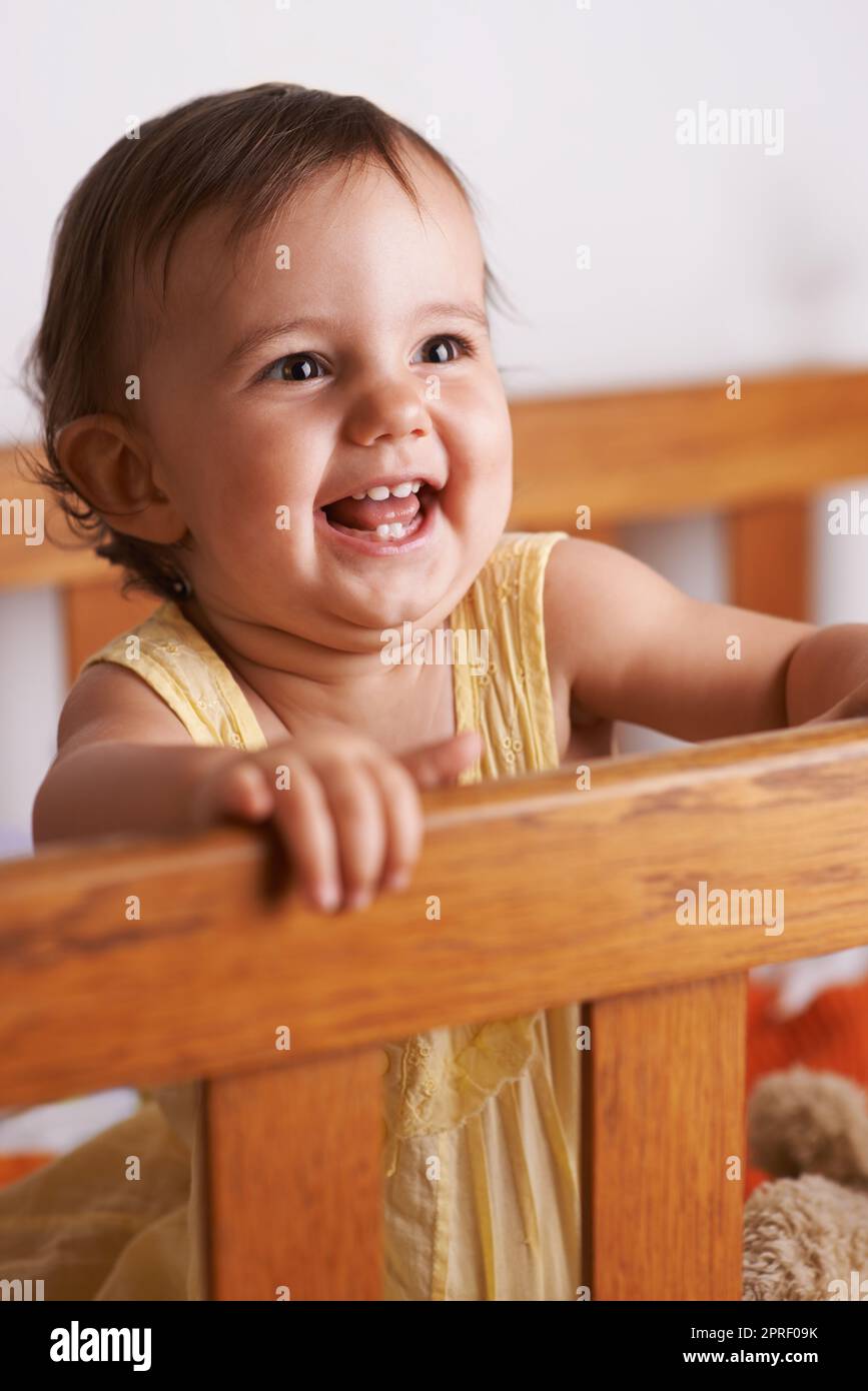 Shes so cute and happy. A cute litlle baby girl laughing as she stands