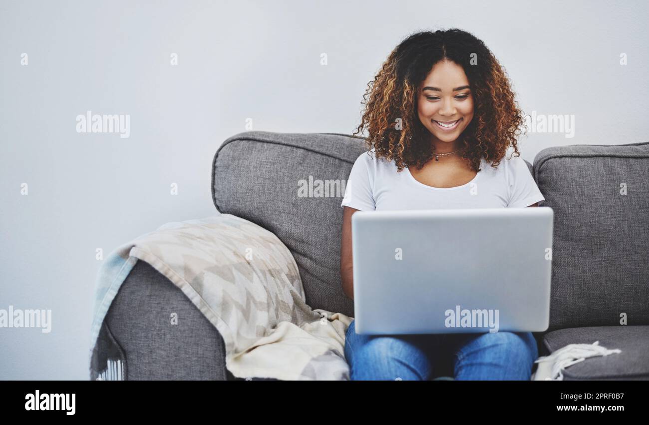 Weekends are for updating my blog. an attractive young woman using a laptop at home. Stock Photo