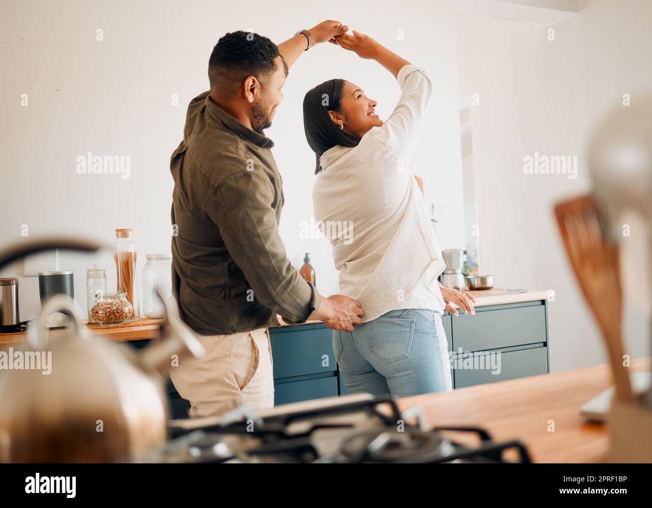 Dancing, romance and playful couple having fun, love and bonding while laughing, spinning and twirling together at home. Loving husband enjoying care, affection and joy while relaxing with happy wife Stock Photo