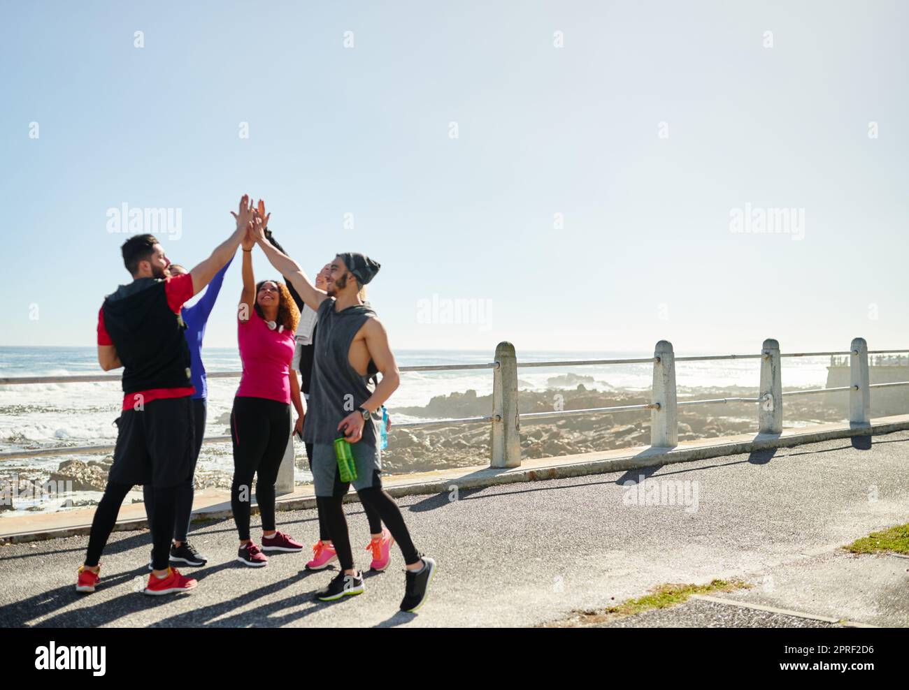 We got this one in the bag. a group of young cheerful friends forming a huddle before a fitness exercise outside during the day. Stock Photo