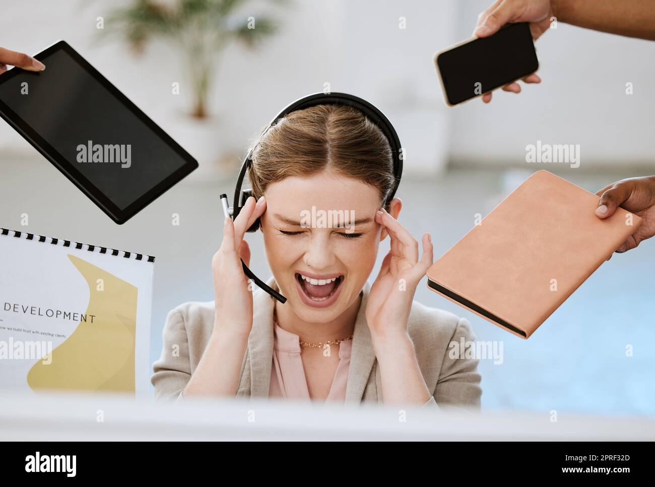 Stress, burnout and overloaded woman at work in a modern office. Female contact centre agent overwhelmed with all the work from her call center colleagues with anxiety and headache in the workplace. Stock Photo