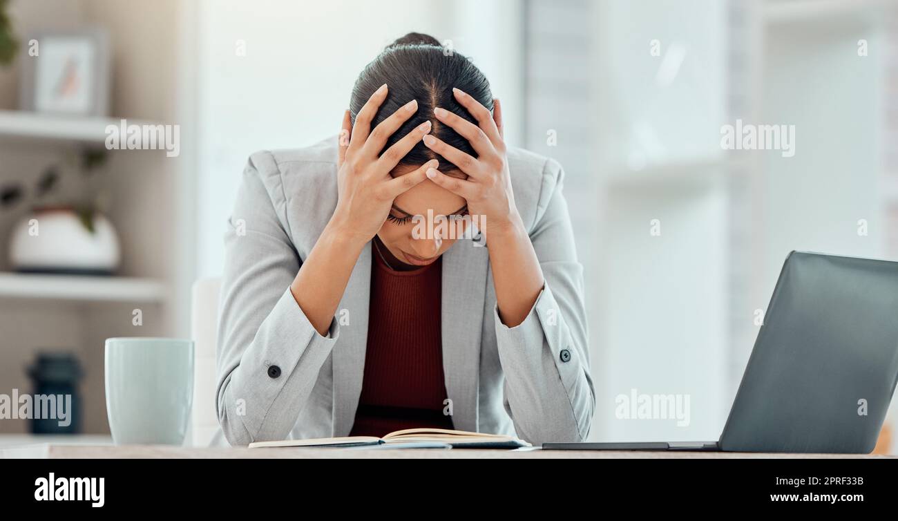 Headache, stress and worried young businesswoman tired from getting bad news about company investment. Professional finance, business female or accountant upset over financial problem or crisis. Stock Photo