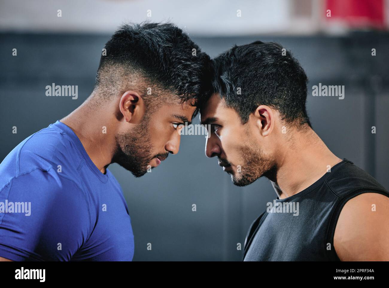 Healthy, serious and fit male athletes staring, facing and looking ready before a fight. Strong young men in an active challenge, a battle of power against strength and a motivation for winning. Stock Photo