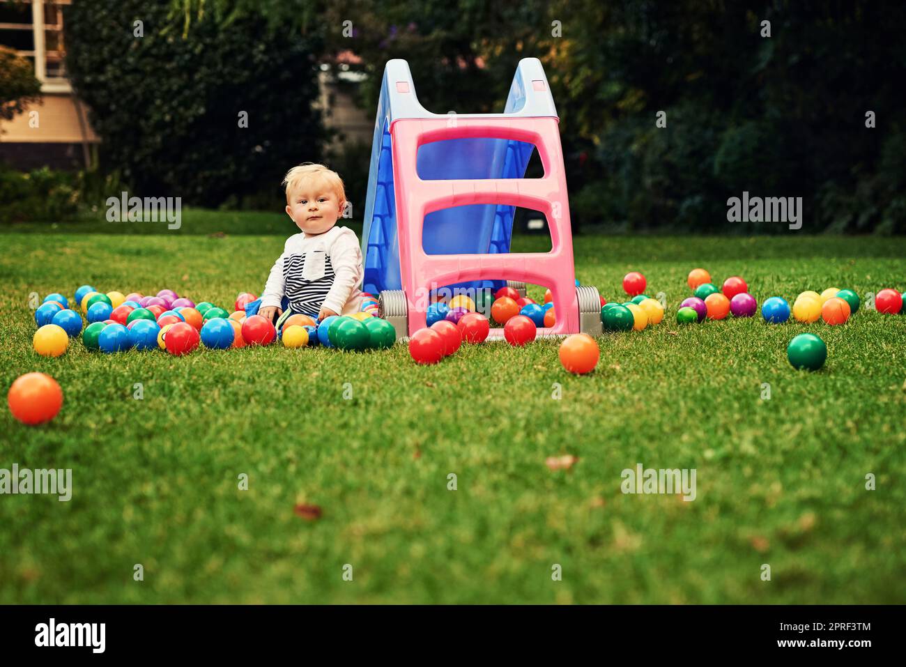 The perfect playground for me. an adorable little boy playing in the backyard. Stock Photo
