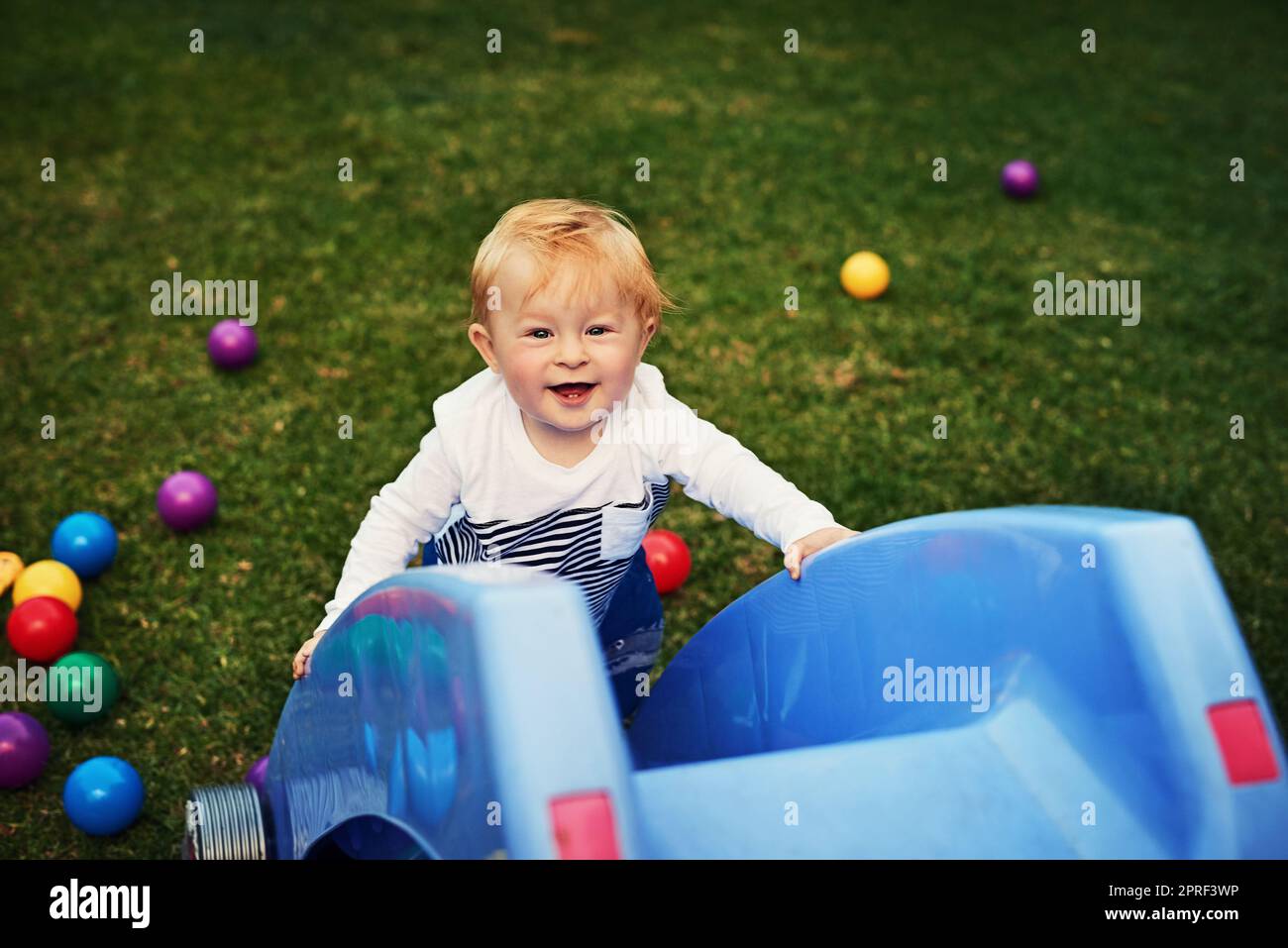 Curious to see whats at the top of this slide. an adorable little boy playing in the backyard. Stock Photo