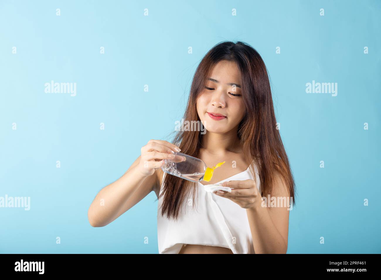 woman drop removing cosmetic make up water to pad cotton face cleaner