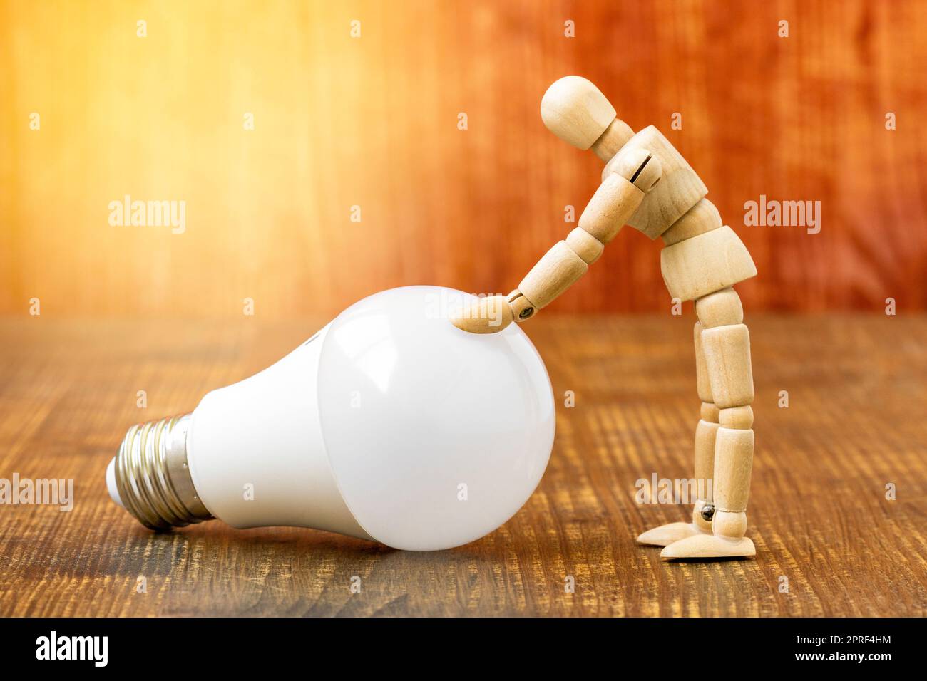 Wooden dummy with LED light bulb on wooden background Stock Photo