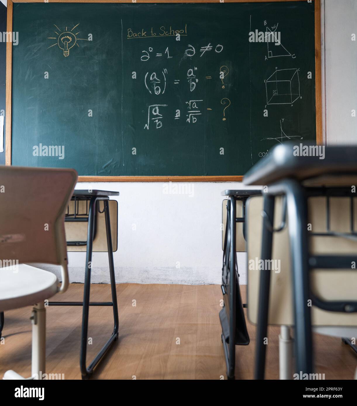 Empty classroom with chairs elementary school desks and chalkboard Stock Photo