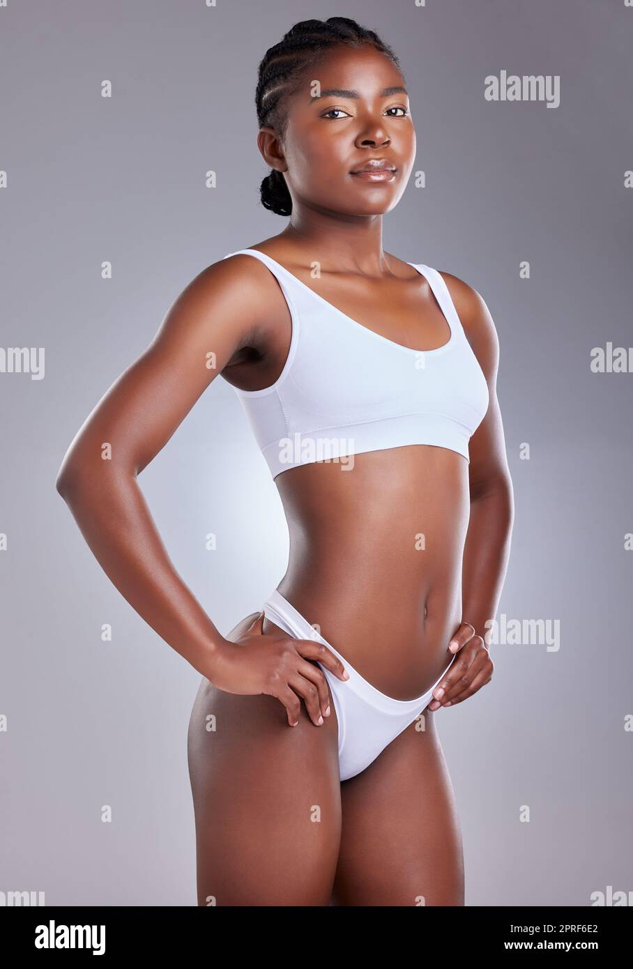 The strength of a woman shouldnt be underestimated. a young woman posing with her arms akimbo against a studio background Stock Photo