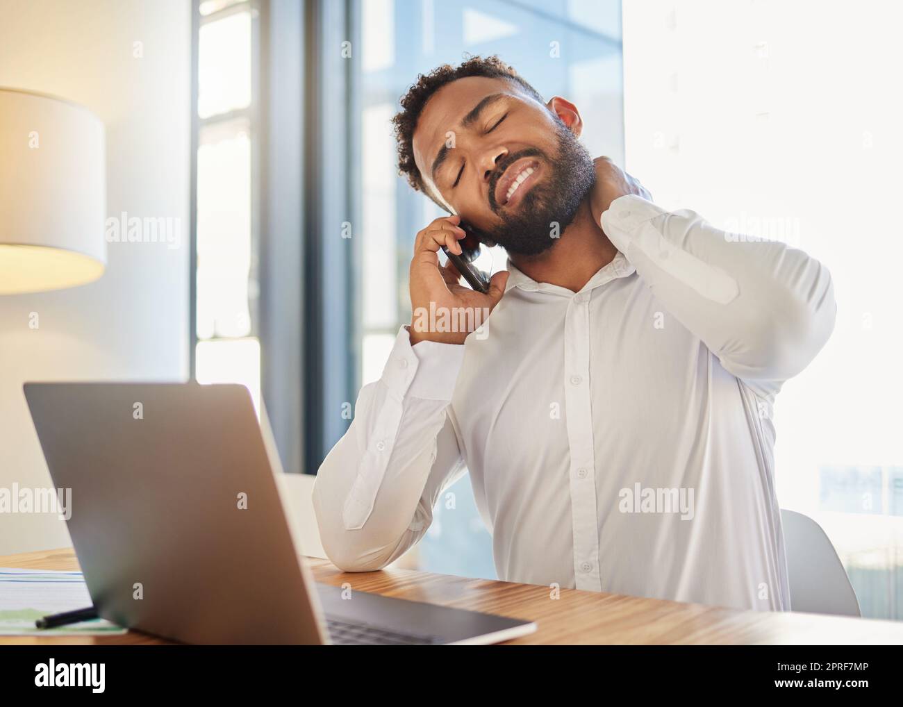 Neck pain, muscle and work stress of a corporate man on a business call at a computer. Tired businessman worker with burnout anxiety working online on a internet finance risk report with a headache Stock Photo