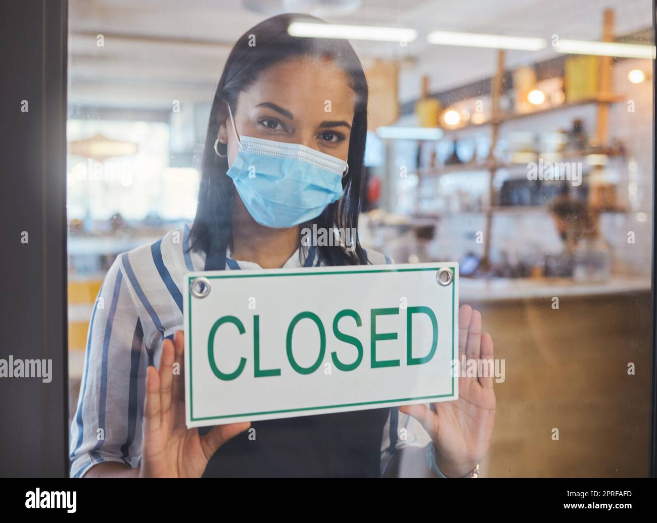 Compliance, safety and economic crisis closing store due to covid19 pandemic, sad and in debt. Small business owner frustrated about fail startup, hanging a sign on the window or entrance of shop Stock Photo