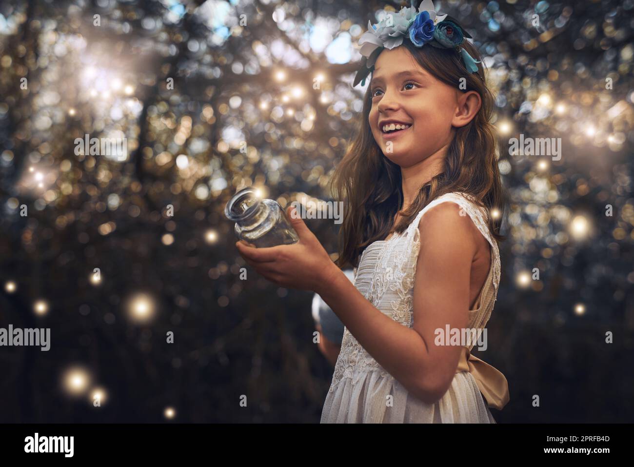 Fun with fireflies. a little girl catching fireflies in a jar outside. Stock Photo