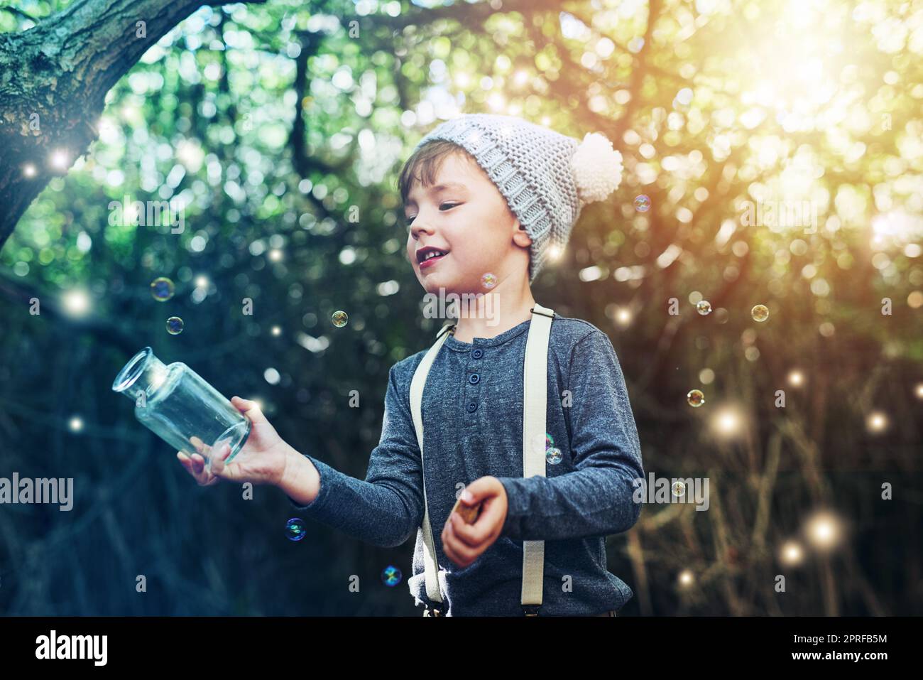 Im gonna catch you all. a little boy catching fireflies in a jar
