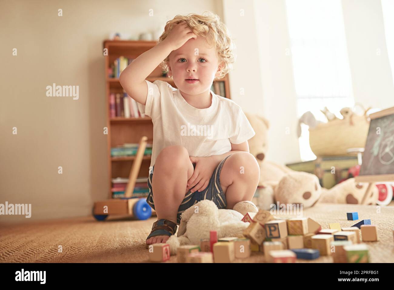 Oops They all came falling down. Portrait of an adorable little boy playing with wooden blocks at home. Stock Photo
