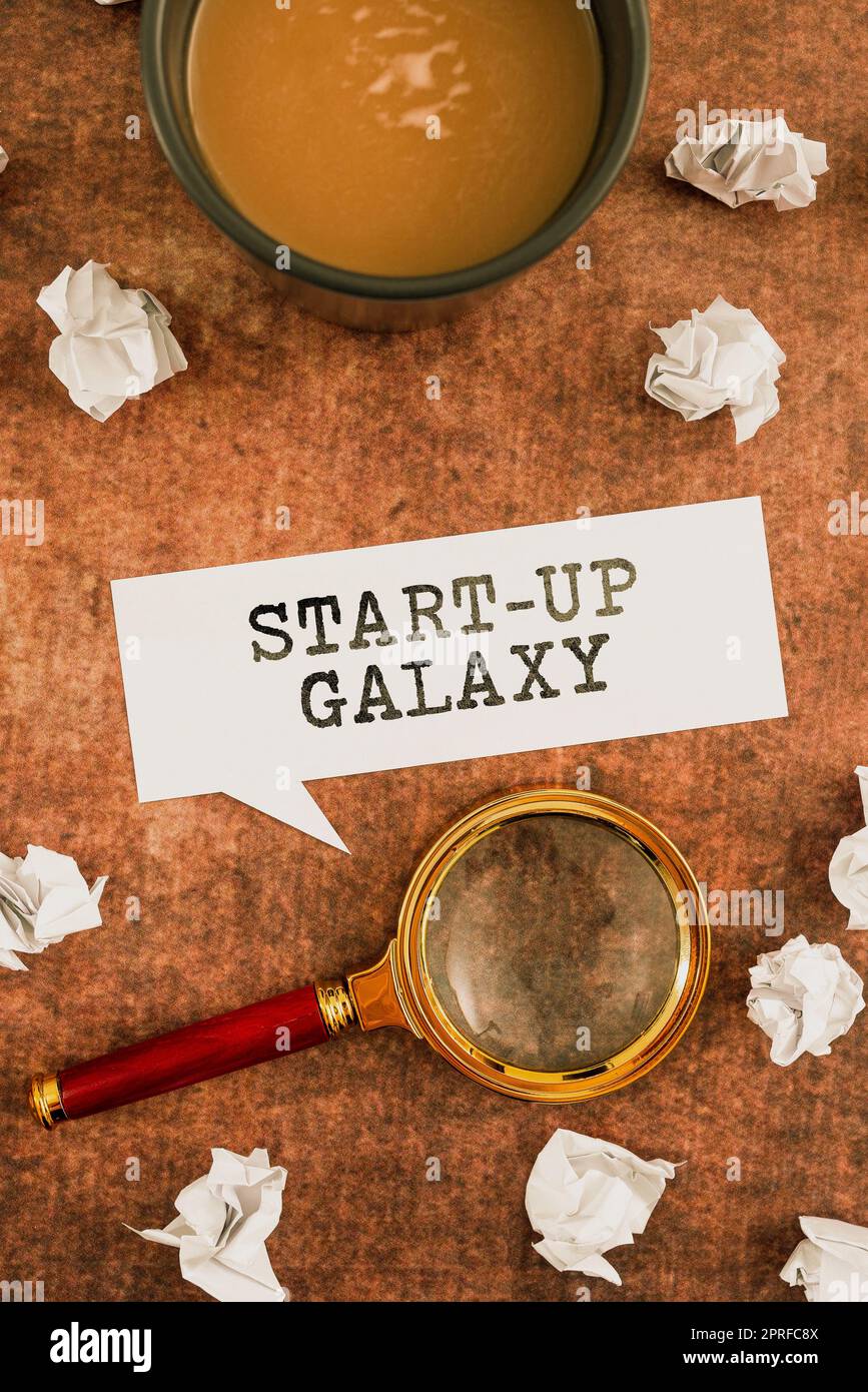 Text sign showing Start Up Galaxy. Conceptual photo Newly emerged business created by new entrepreneurs Two Colleagues Standing Discussing New Ideas With Big Speech Bubble Stock Photo