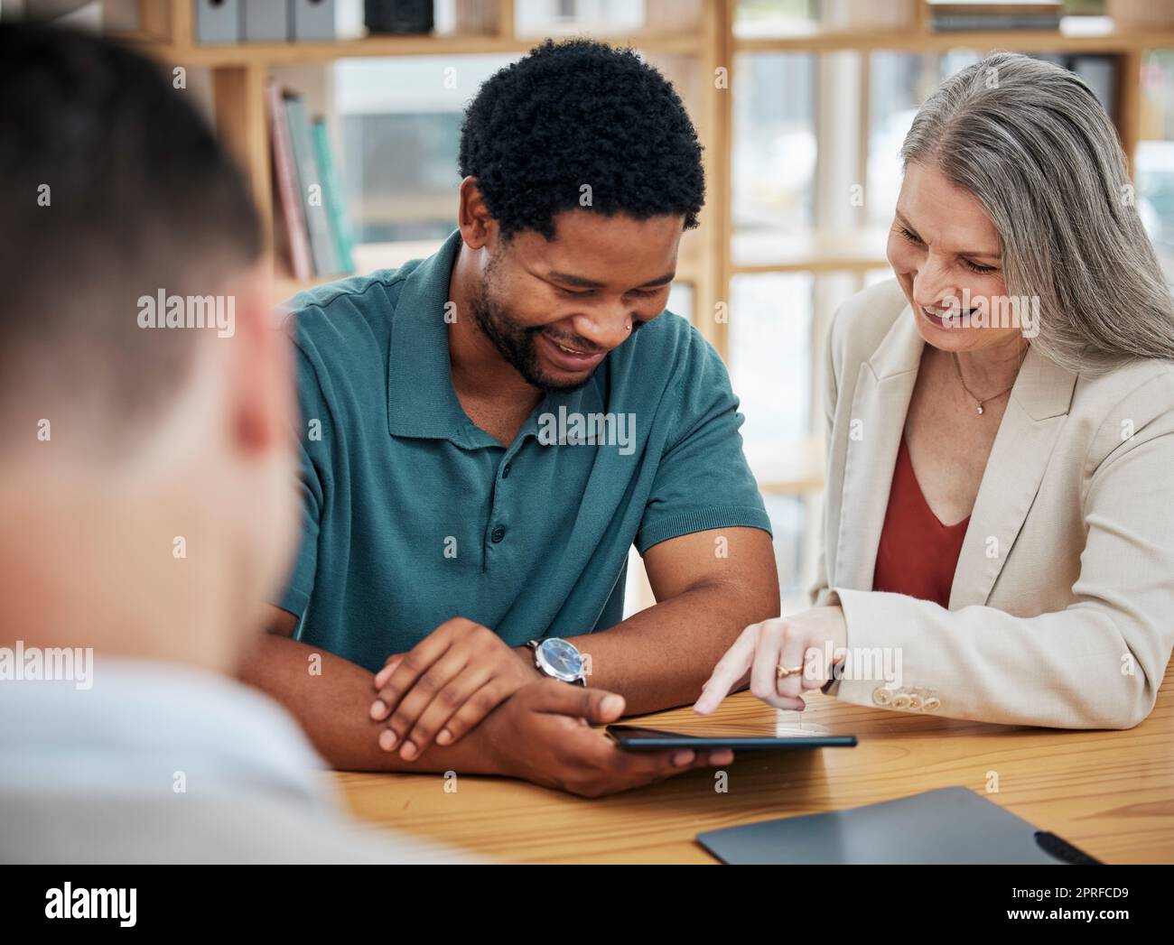 Female manager boss or leader meeting with an employee with a digital tablet. Intern, project supervisor discuss online work or report in the boardroom. Businessman and lady talk strategy development Stock Photo