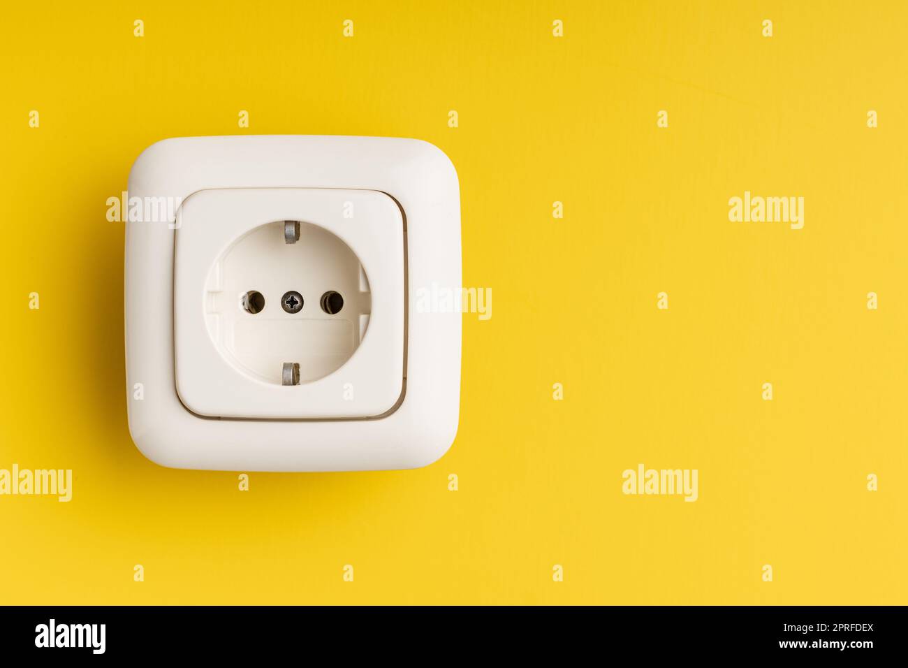 Wall socket on yellow wall. Stock Photo