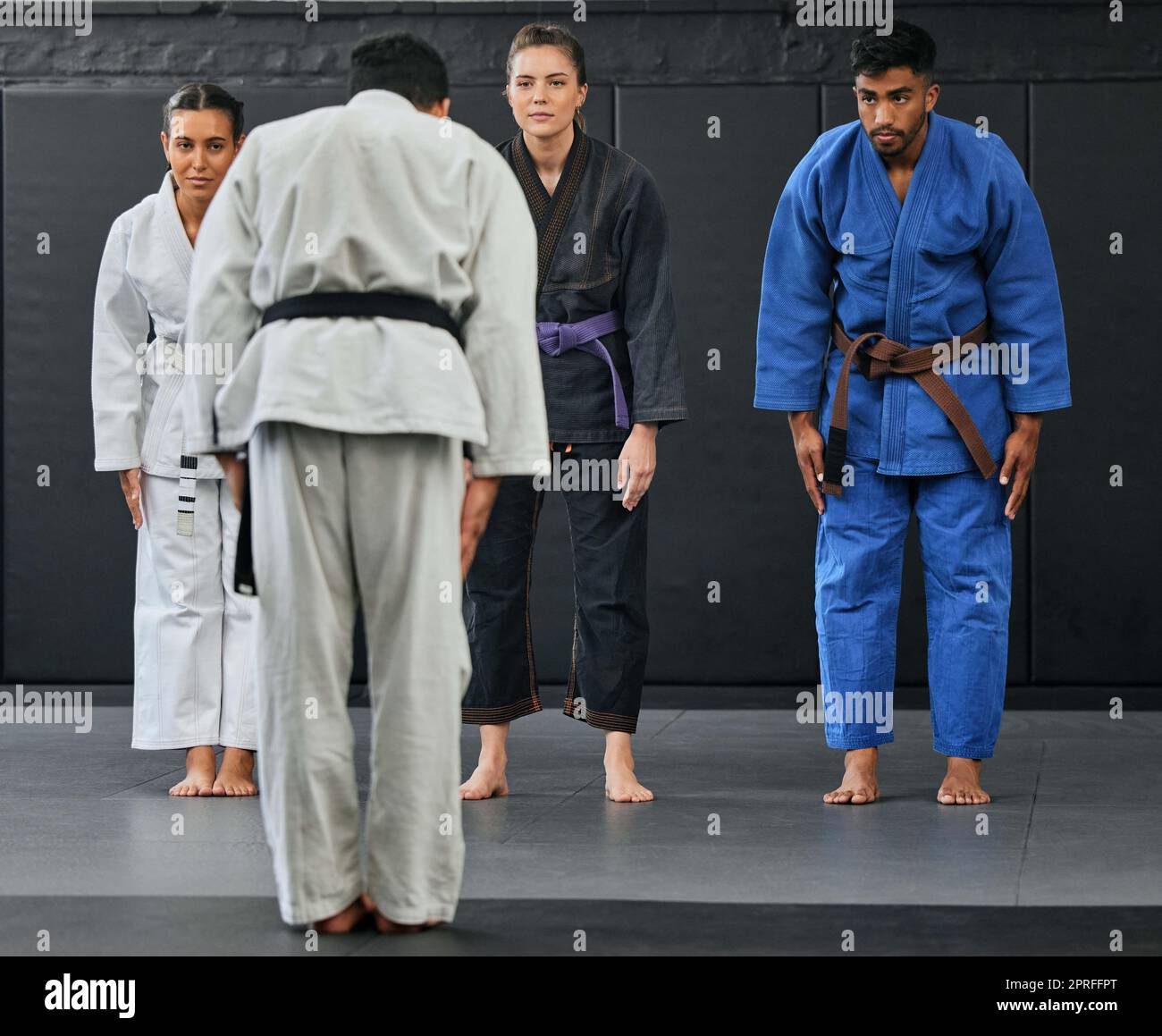 Karate coach teaching a fitness class at gym, students learning self defense training exercise with trainer and doing cardio workout at sports center. Healthy people doing martial arts hobby Stock Photo
