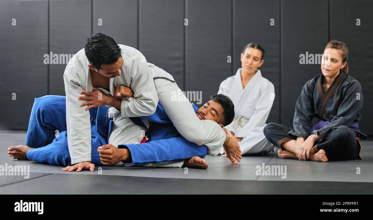 Fight, karate class and martial arts teamwork in competition, challenge or self defense sport in wellness school. Fitness sports coach teaching students gym workout, floor exercise or health training Stock Photo