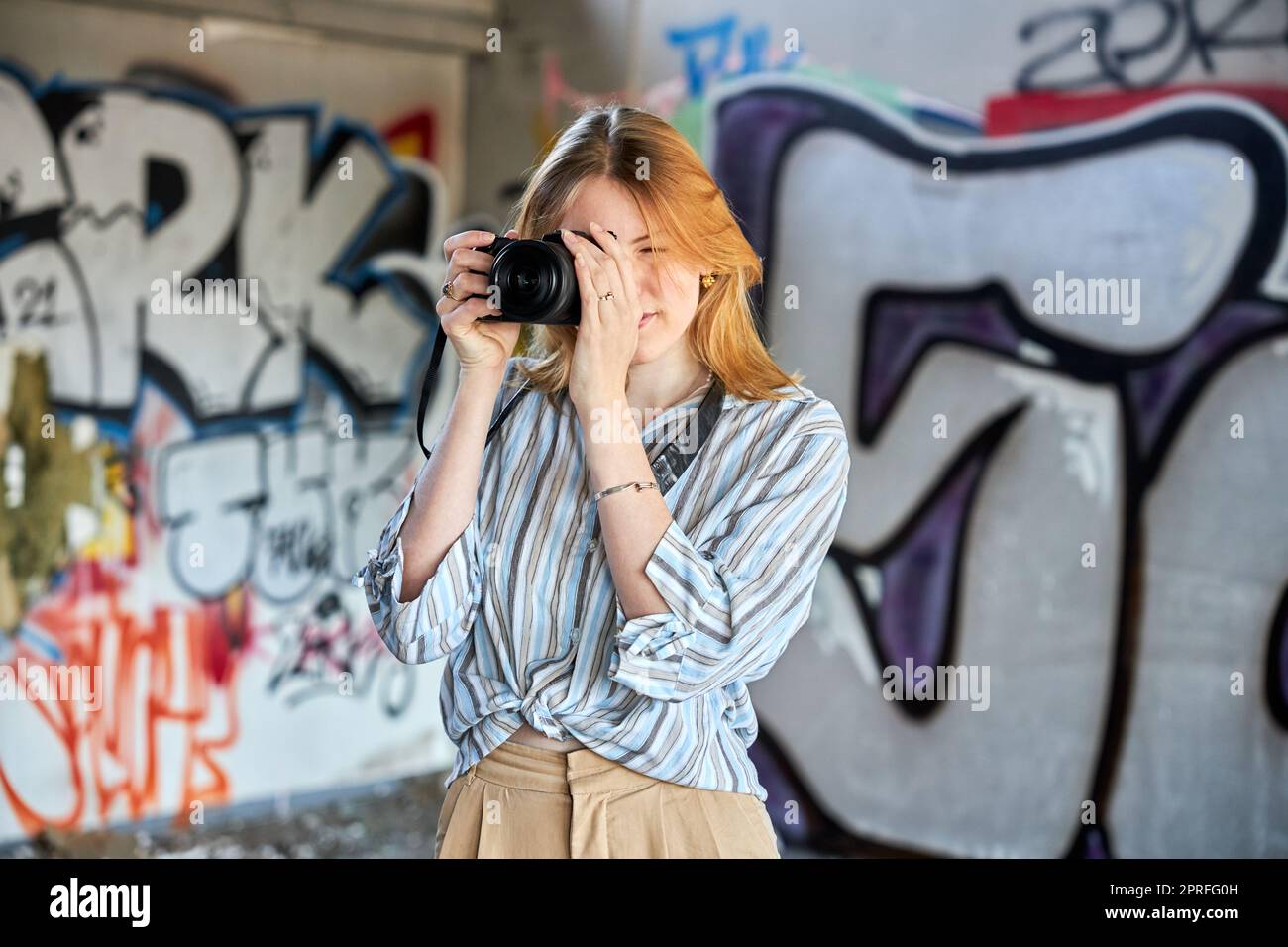 Red hair girl in a building with a camera Stock Photo