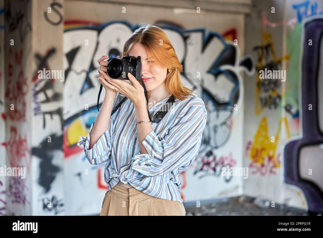 Red hair girl in a building with a camera Stock Photo