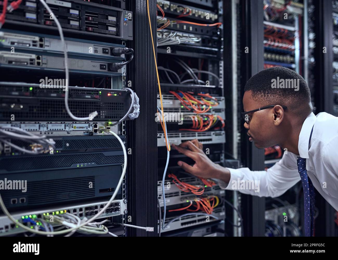 No room for error. a IT technician working and checking if all the servers are up and running. Stock Photo